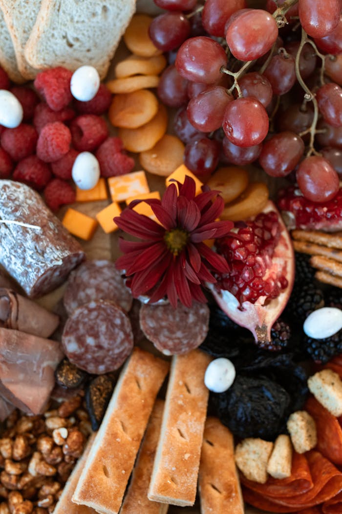 About Artfully arranged charcuterie board featuring meats, cheeses, fruits, and nuts.